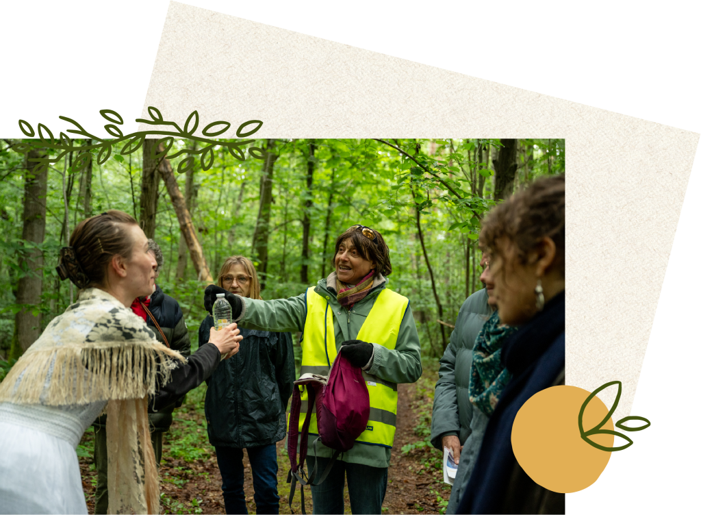 Une actrice vêtue de blanc interagit avec un membre du public lors d'une performance théâtrale en forêt. La balade en forêt se déroule dans le cadre immersif et éco-sensible de 'Les Écorcées', renforçant le lien entre nature et art.