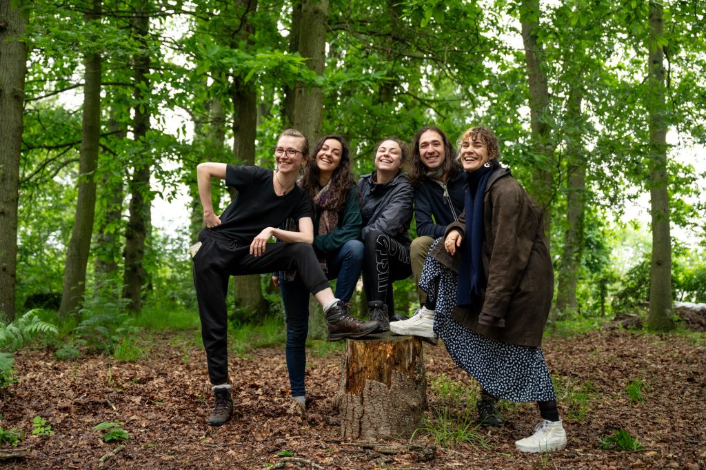 Les cinq artistes de l'équipe une forêt verdoyante dans le cadre du spectacle déambulatoire de théâtre-paysage 'Les Écorcées si la forêt contait'